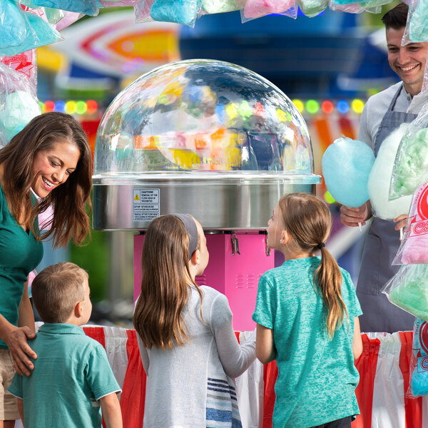 A woman and children using a Carnival King cotton candy machine with a Floss Bubble.