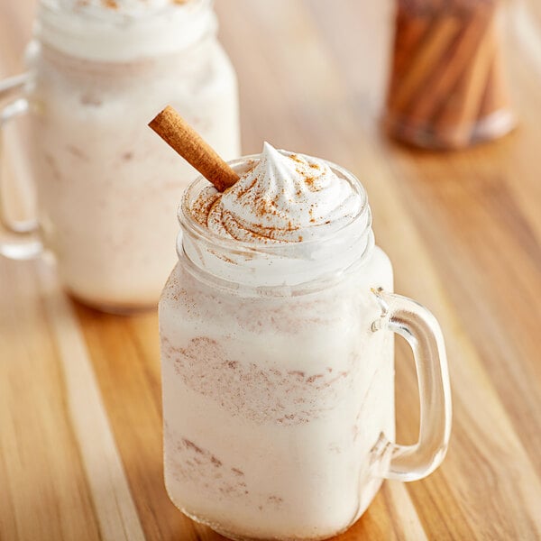 A glass mug filled with Big Train Vivaz Horchata Frappe Mix with whipped cream and cinnamon on top.