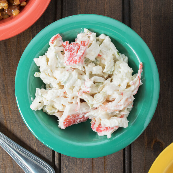 A bowl of crab salad in a rainforest green melamine bowl.