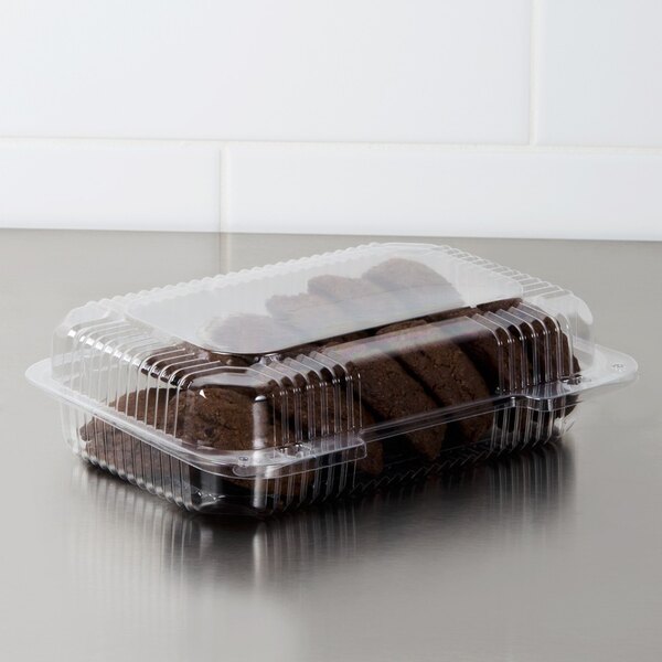 A Dart clear plastic oblong container with brown cookies inside.