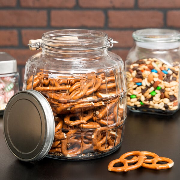An Anchor Hocking Barrel Jar filled with pretzels and nuts.