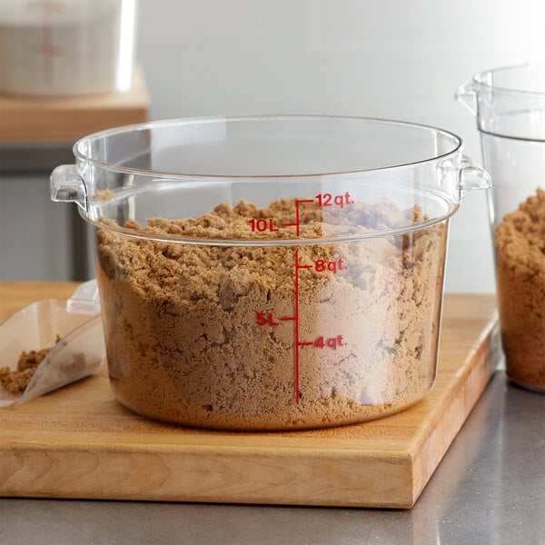 A clear Cambro round food storage container with brown powder inside.
