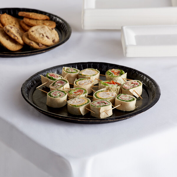 A Solut Black Elegance catering tray with sandwiches and cookies on it.