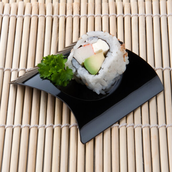 A sushi roll with avocado and cheese on a black Fineline Tiny Temptations tray.