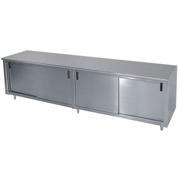 A stainless steel cabinet with drawers and doors under a long stainless steel work table.