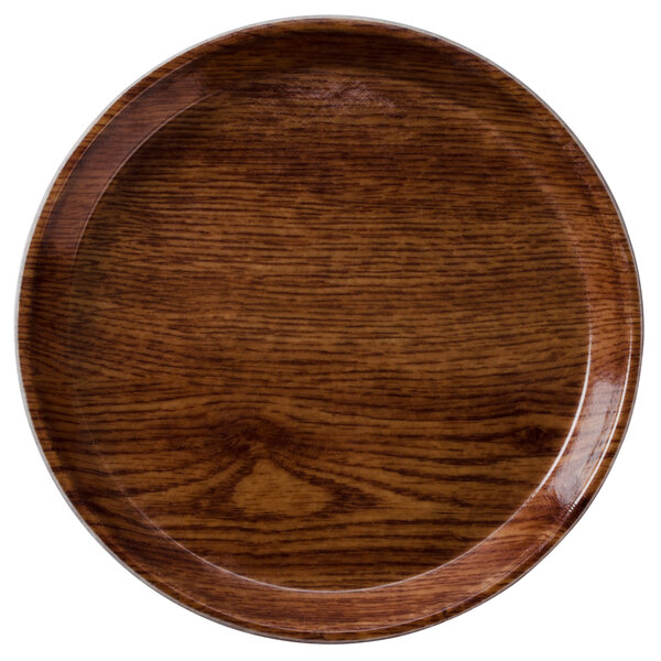 A round wooden Cambro tray with a brown wood grain rim.