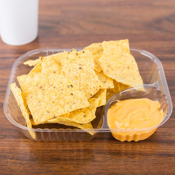 A Dart plastic nacho tray with chips and sauce in it.