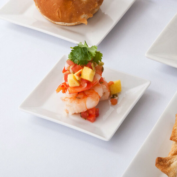 A 3" bright white square porcelain plate with shrimp, tomatoes, and bread on it.