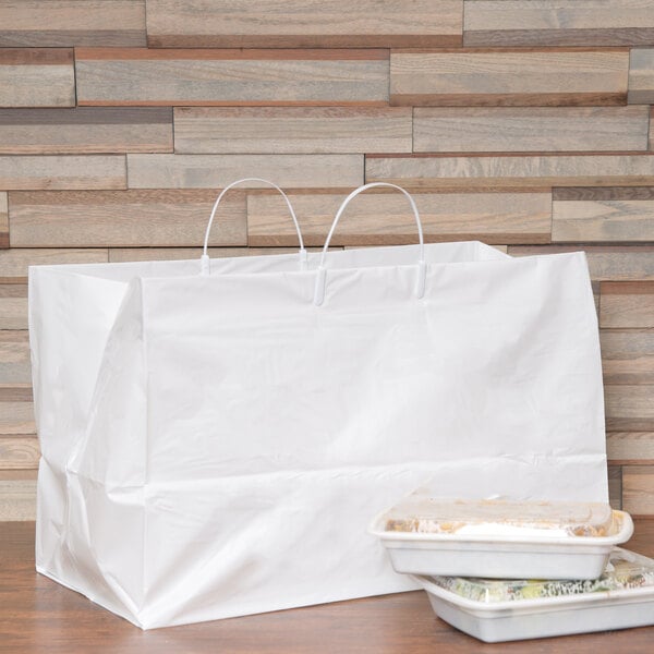 A white bag with handles next to food containers.