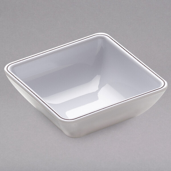 A white square bowl with a silver rim.