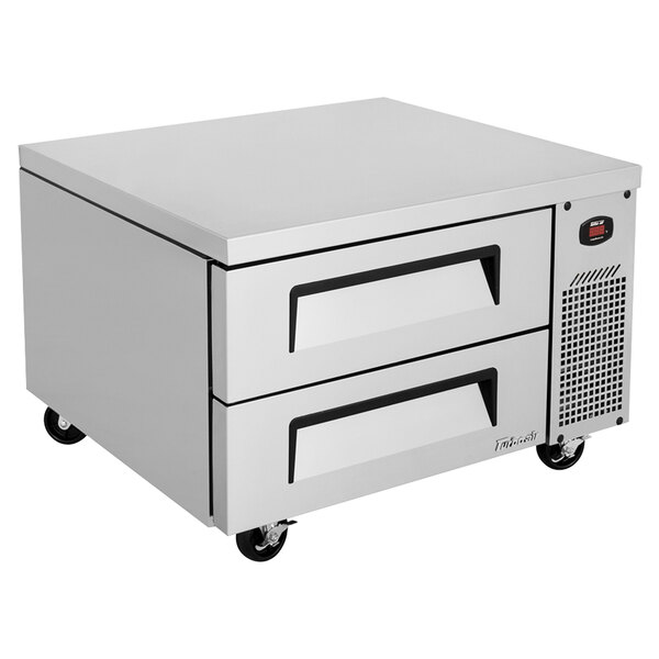 A stainless steel Turbo Air two drawer refrigerated chef base on black wheels.