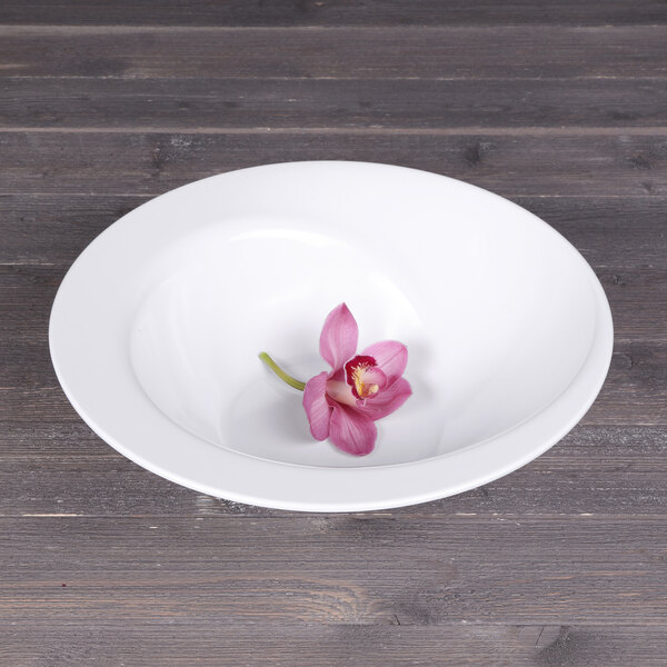 An Elite Global Solutions white melamine bowl with a flower in it.