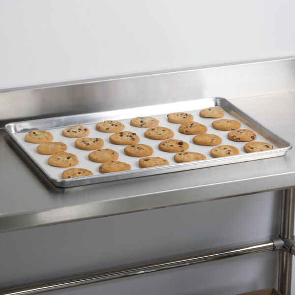 An Advance Tabco wire in rim aluminum sheet pan holding cookies on a metal surface.