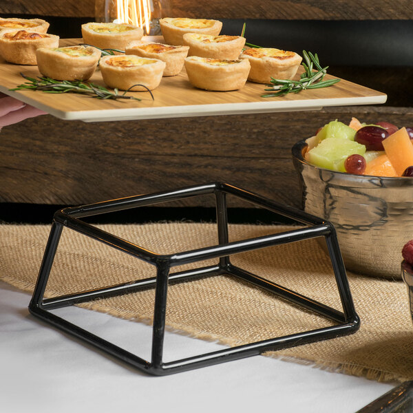 A table with a metal stand holding a tray of food on it.