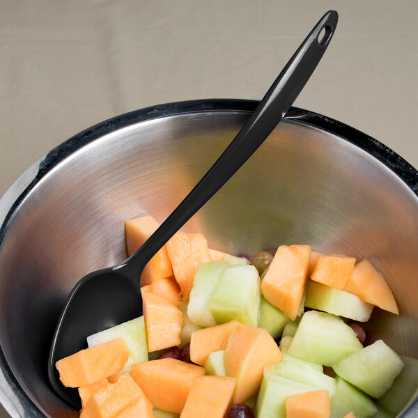 A bowl of fruit with a spoon.