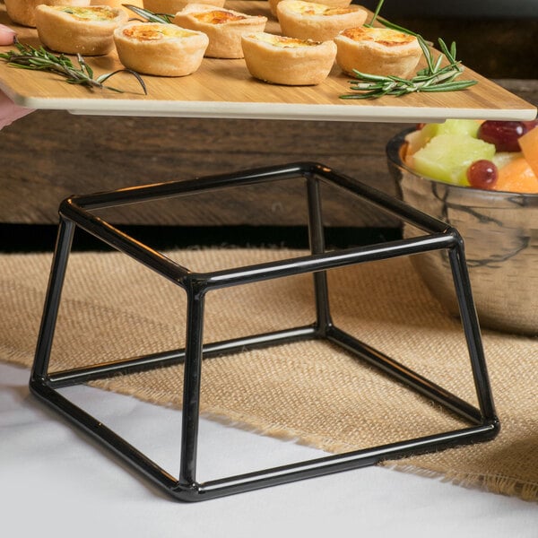 A metal stand with a tray of food on a table.