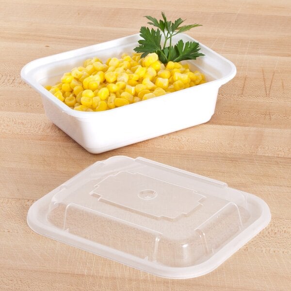 A white Pactiv plastic food container with corn and parsley.