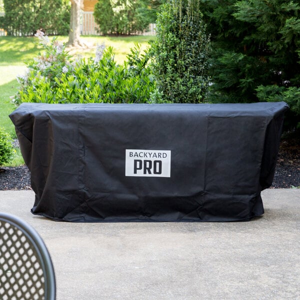 A black Backyard Pro grill cover with the word "Pro" in white.
