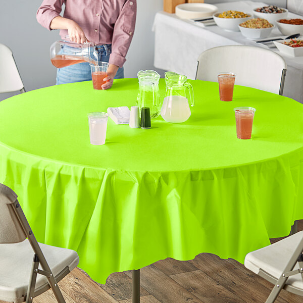 A woman sitting at a table with a Fresh Lime Green OctyRound table cover.