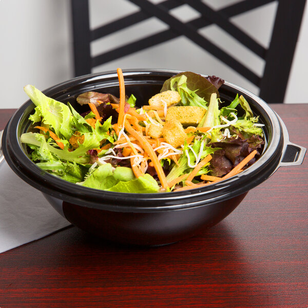 A bowl of salad with carrots and chicken in a black Fineline PET plastic bowl.