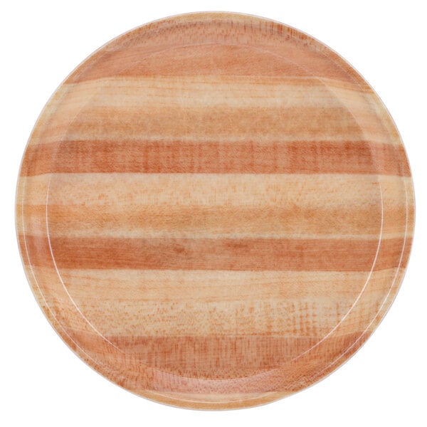 A close up of a Cambro fiberglass round butcher block tray with a wooden plate design and white rim.