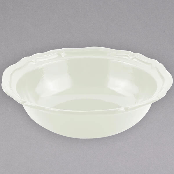 A Bon Chef ivory sandstone salad bowl with a scalloped edge.