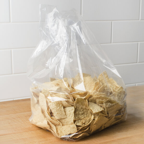 A box of LK Packaging plastic food bags on a counter with a bag of chips inside.