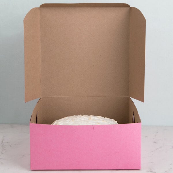 A pink box with a cake inside it.