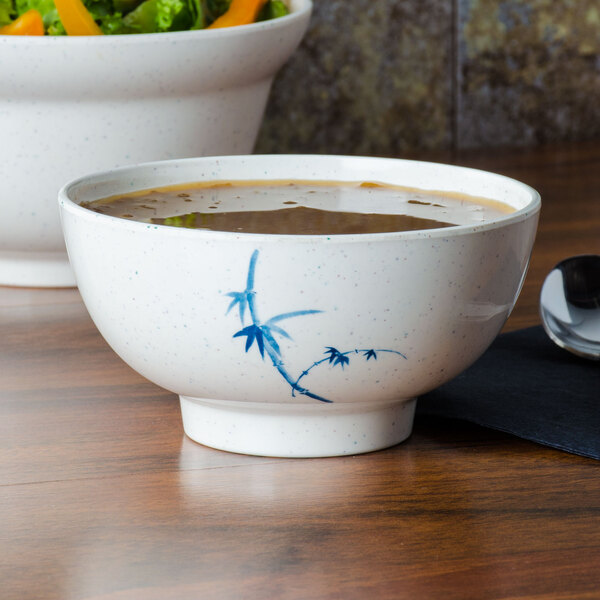 A Thunder Group Blue Bamboo melamine bowl with lid filled with soup on a counter.