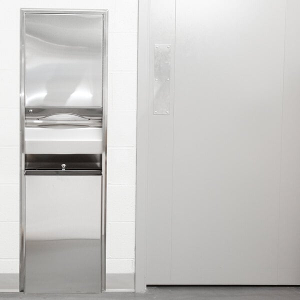 A Bobrick stainless steel rectangular paper towel dispenser and waste receptacle on a white wall.