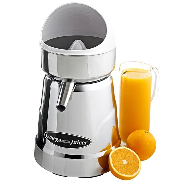 A silver Omega commercial citrus juicer next to oranges and a glass of orange juice.