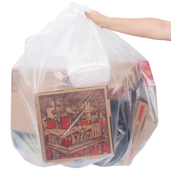 A hand holding a Berry low density plastic bag full of pizza boxes.