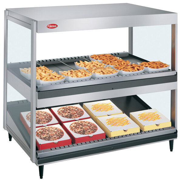 A Hatco countertop food warmer with trays of french fries in it.