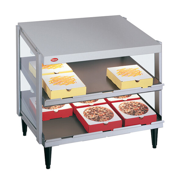 A Hatco countertop pizza warmer with two metal shelves holding pizza boxes.