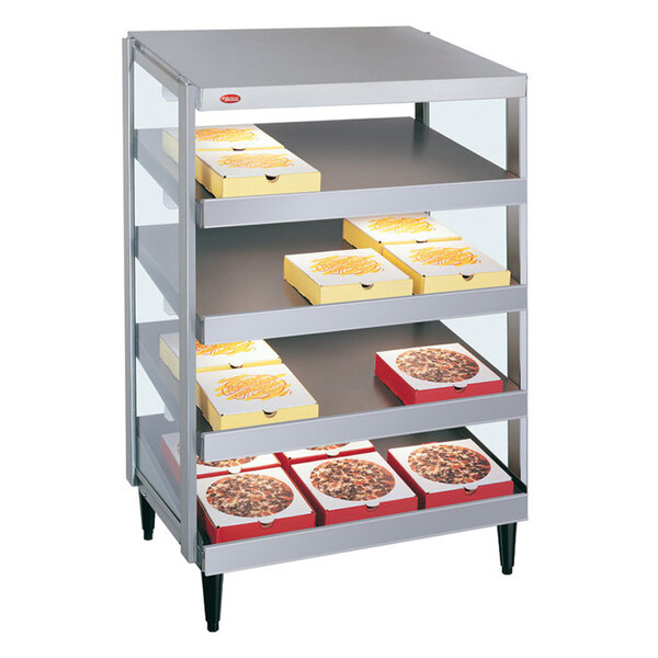 A Hatco countertop pizza warmer with trays of pizza in yellow and white boxes on metal shelves.