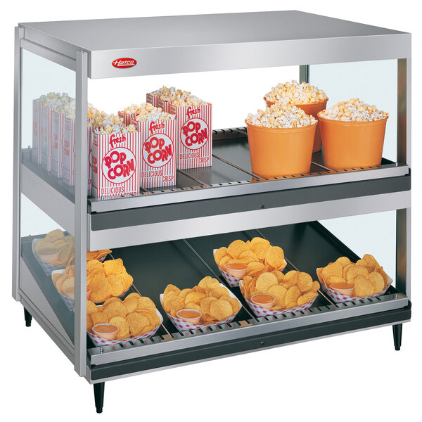 A Hatco countertop food warmer with popcorn and potato chips on it.