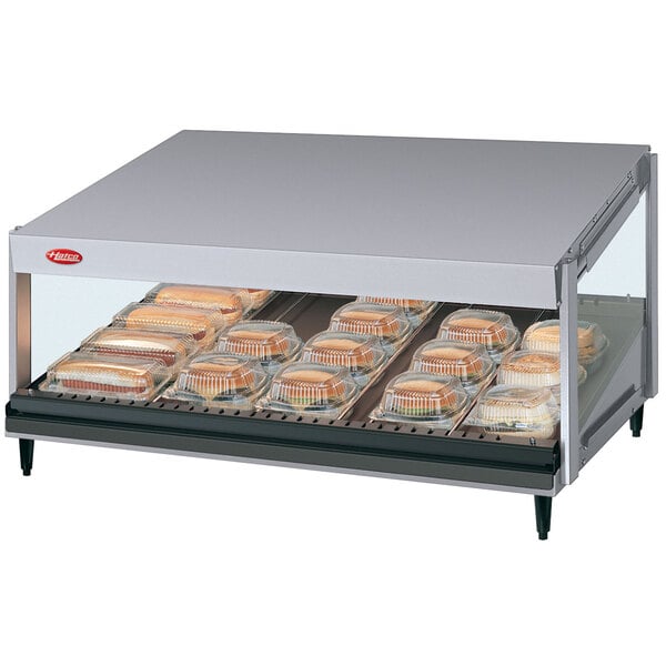 A Hatco countertop slanted glass display case with food inside.