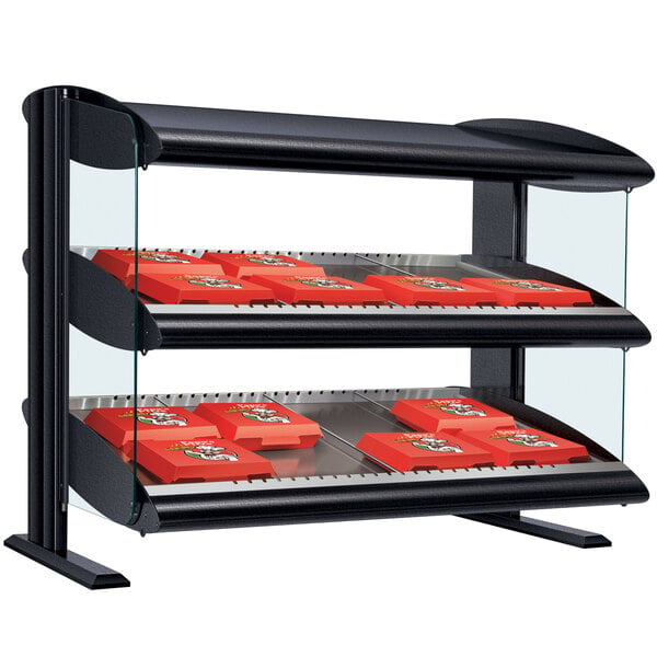 A Hatco slanted double shelf merchandiser on a counter with red trays on it.