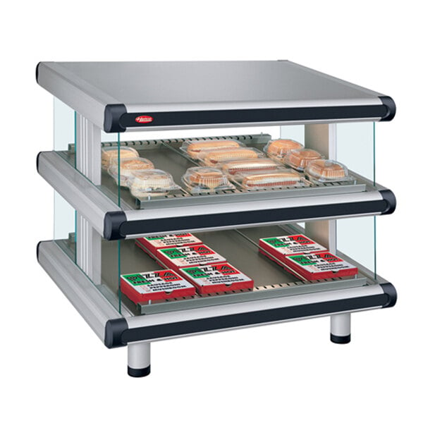 A Hatco countertop display case with slanted glass shelves holding food trays.
