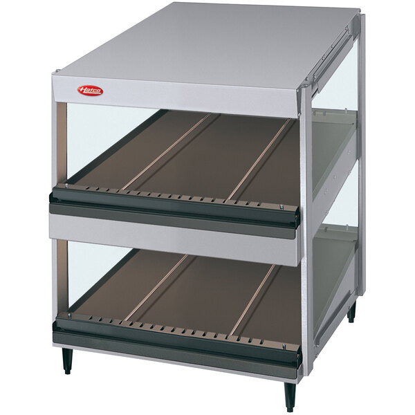 A silver Hatco countertop unit with two slanted shelves holding food.