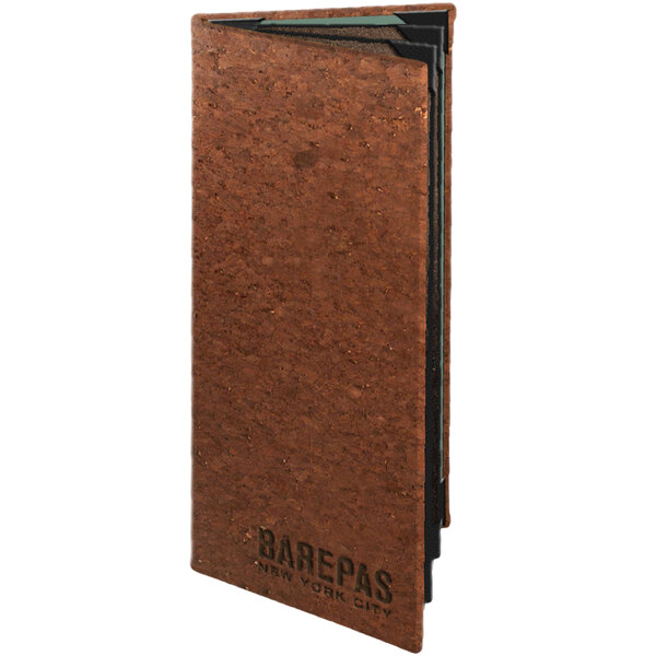 A Menu Solutions cork menu cover on a brown surface.