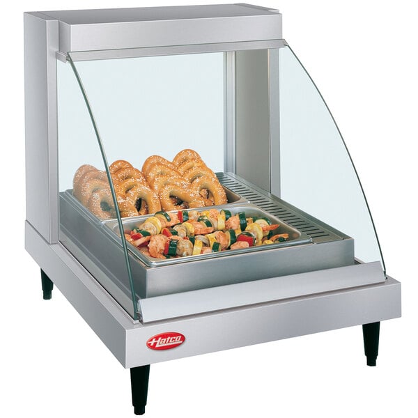 A Hatco countertop food warmer with a shelf of food on display inside a glass case.