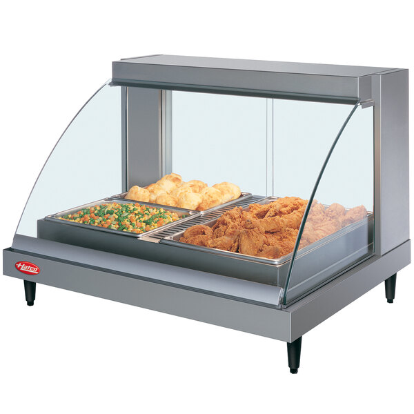 A Hatco countertop food warmer with a glass cover over food.