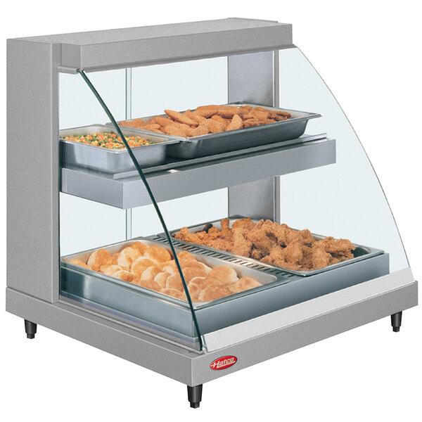 A Hatco countertop double shelf hot food display case with food in it.