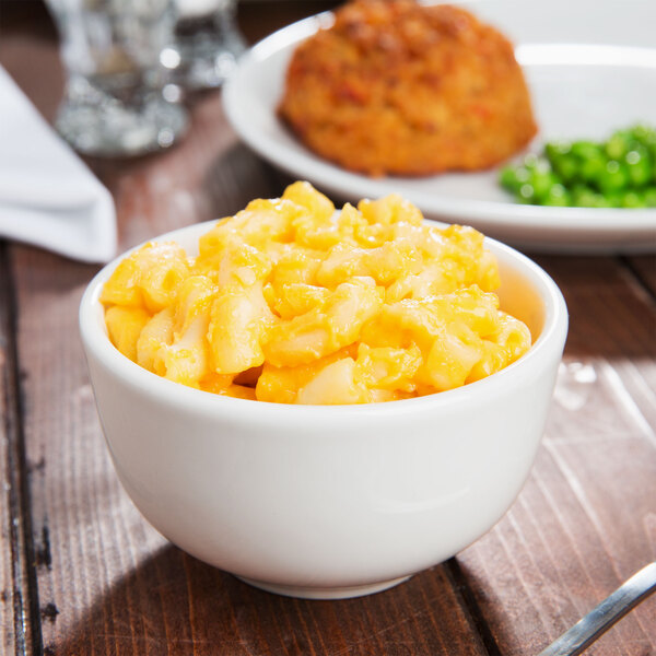 A bowl of macaroni and cheese with peas and carrots in a Tuxton AlumaTux pearl white china bowl.