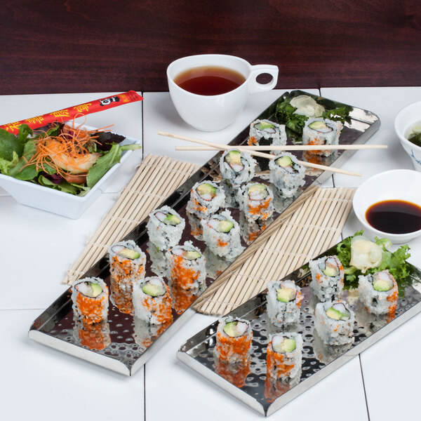 A hammered stainless steel tray with sushi on a table.