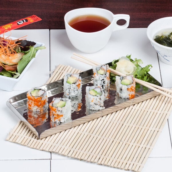 A plate of sushi on an American Metalcraft hammered stainless steel tray with chopsticks.