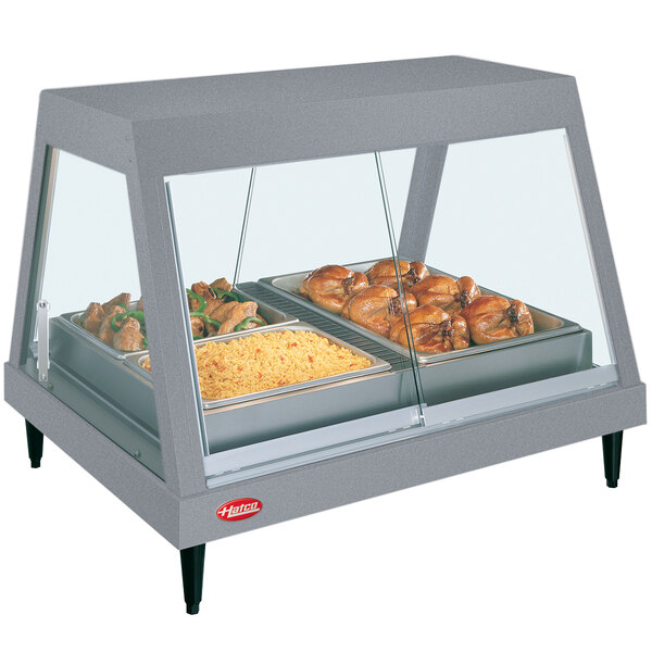 A Hatco countertop food warmer with food trays holding chicken and rice.