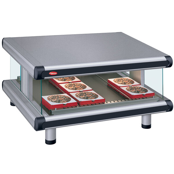 A Hatco countertop food warmer with pizza on a slanted shelf.
