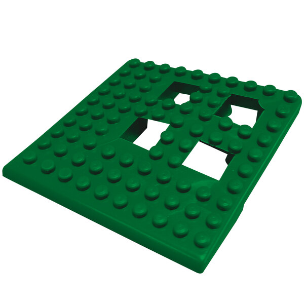 A green square corner piece of Cactus Mat Dri-Dek with holes in it.